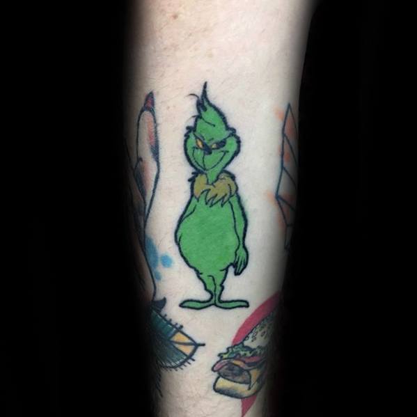 Grinch standing with a mischievous expression, outlined in bold black lines with vibrant green and yellow details, creating a playful tattoo design.