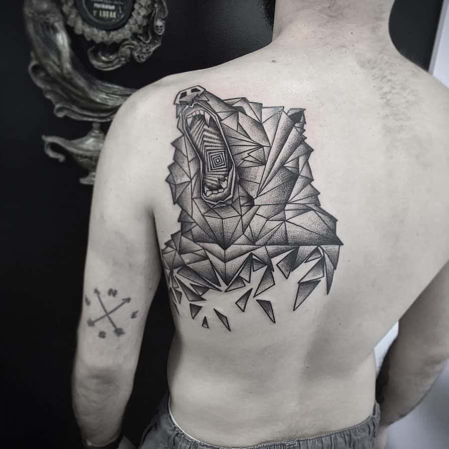 Back tattoo of a roaring bear in a geometric, fragmented style, combining bold shading and sharp angles for a powerful modern design.