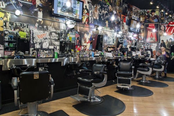 Barbershop with rock-and-roll poster walls, black chairs, and a modern industrial vibe.