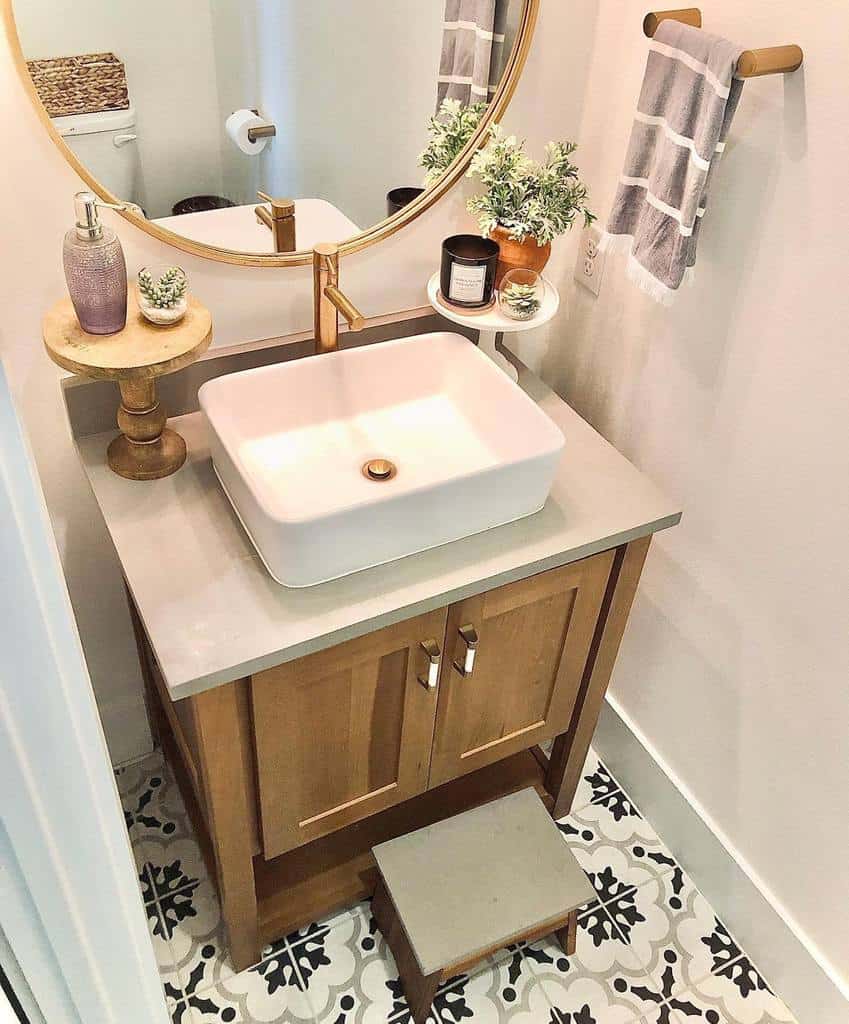 modern bathroom white sink wood vanity gold accent mirror pattern floor tiles