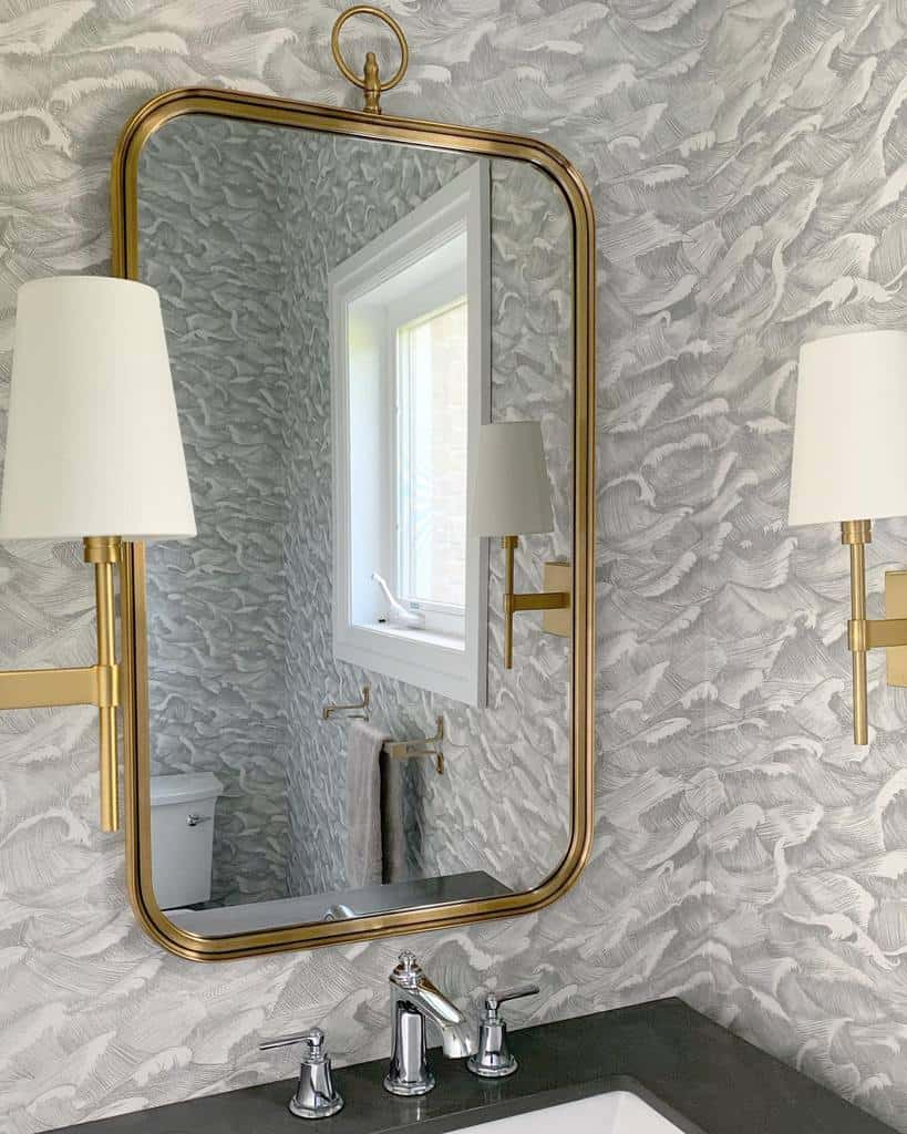 luxury bathroom wave wallpaper gold rimmed mirror and sconces lighting