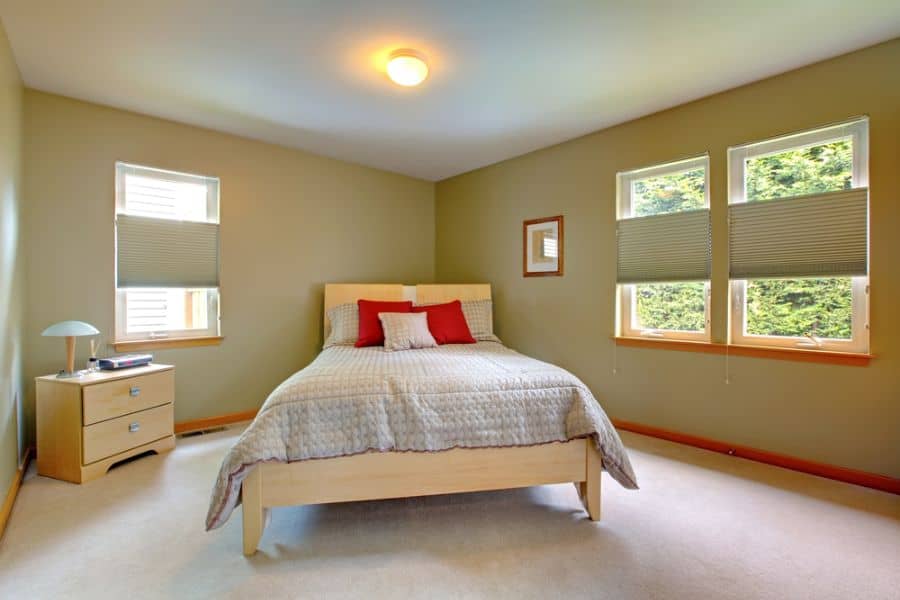 minimalist guest bedroom wood bed frame and cabinet green walls