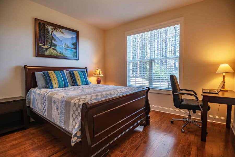 wood flooring spare bedroom with desk and brown wood bed frame