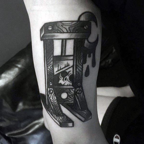 Bold blackwork guillotine tattoo with abstract patterns, skull detail, dripping shapes, and a crescent moon on the top corner.