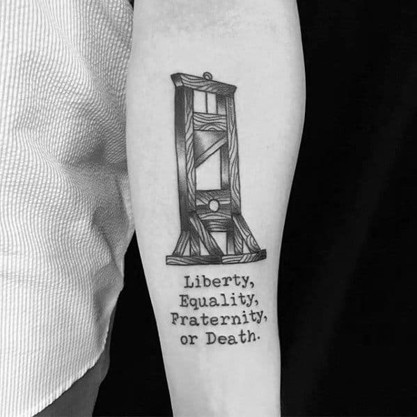 Black ink guillotine tattoo with wood grain detail, paired with the phrase “Liberty, Equality, Fraternity, or Death.” below.