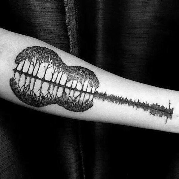 Black and grey forearm tattoo of a guitar-shaped forest reflection with trees forming the body and a soundwave-inspired neck, blending nature and music.