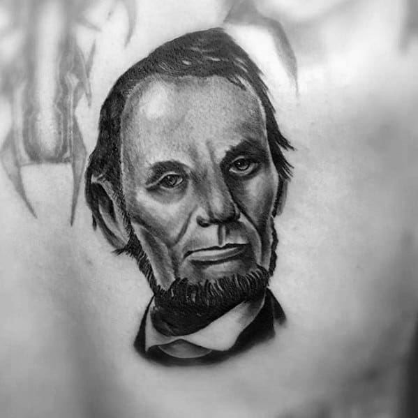 Black and white portrait tattoo of a bearded man resembling Abraham Lincoln