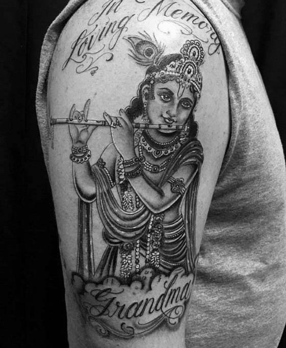 Memorial Krishna tattoo featuring Lord Krishna playing the flute with “In Loving Memory” and “Grandma” text beautifully integrated below.