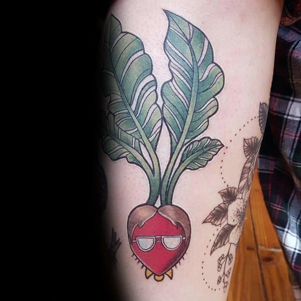 Color tattoo of a beet with Dwight Schrute’s face from The Office, featuring his signature glasses and hair, referencing Schrute Farms.