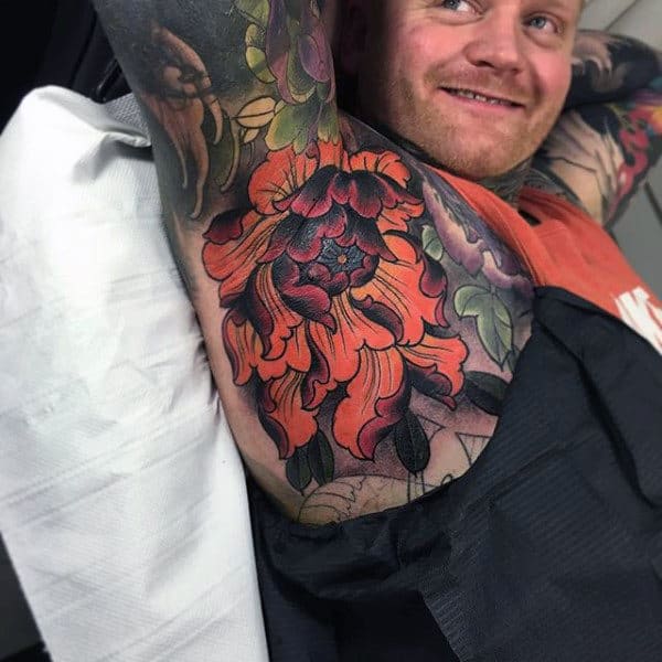 Guy With Bright Orange Florals Tattoo On Armpits