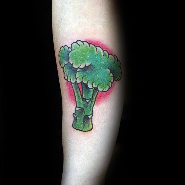 Bright broccoli tattoo on the forearm, featuring bold outlines, vibrant green shading, and a red glow for a striking and dynamic design.