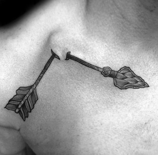 Broken arrow tattoo across the chest with realistic shading, showing a jagged break between the fletching and broad arrowhead.