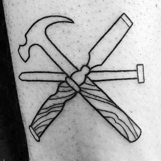 Minimalist black line tattoo of a crossed hammer, chisel, and nail, symbolizing craftsmanship, woodworking, and dedication to the trade.