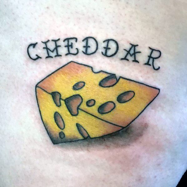 Colorful tattoo of a wedge of cheddar cheese with bold black outlines and smooth yellow-orange shading, featuring the word "CHEDDAR" in stylized lettering above.