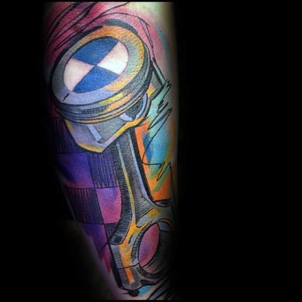 Vibrant BMW piston tattoo on forearm, featuring bold colors and dynamic shading for a striking mechanical and automotive-inspired design.