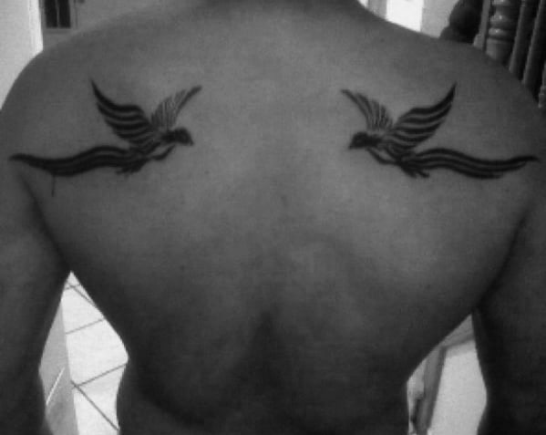Guy With Cool Tribal Back Tattoo Of Two Flying Birds
