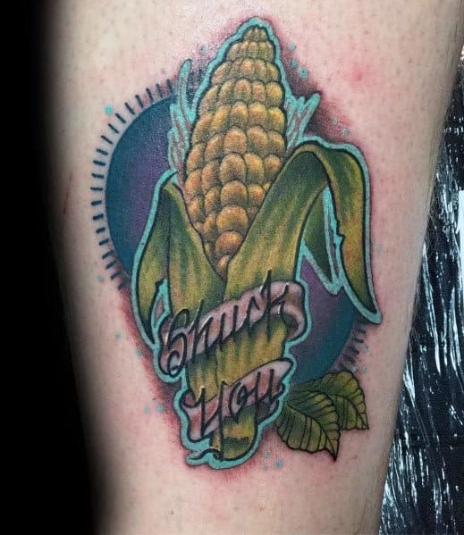 Vibrant tattoo of a corn cob with a bold 'Shuck You' banner, featuring rich colors and dynamic shading for a playful design.