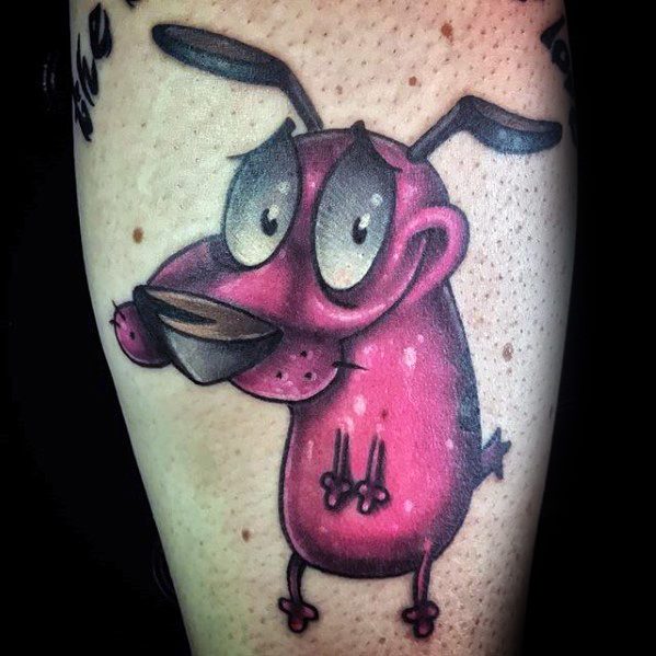 Vivid tattoo of Courage the Cowardly Dog with a shy smile and big eyes, shaded in bold pink and black tones on the calf.