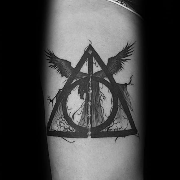 Black ink tattoo combining the Deathly Hallows symbol with a Dementor and wings, creating a dark and powerful Harry Potter design.
