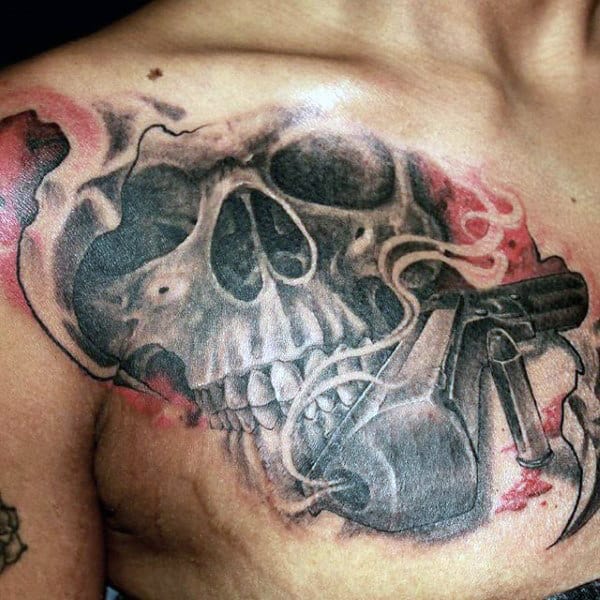 Guy With Evil Skull And Pistol Tattoo On Chest