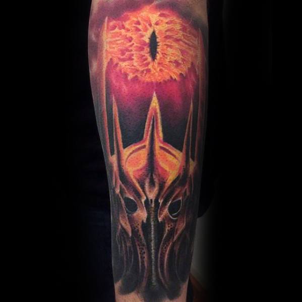 A striking tattoo of the Eye of Sauron blazes above a spiked helmet on an arm
