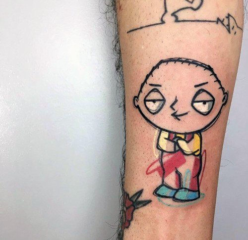 Tattoo of Stewie Griffin from Family Guy with his signature mischievous smirk, hands clasped together, wearing his classic red overalls and yellow shirt.