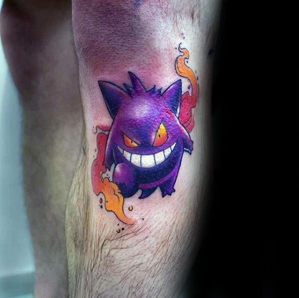 Energetic Gengar tattoo with bright orange eyes, wide grin, and swirling red-orange flames for a bold and fiery ghost-type look.
