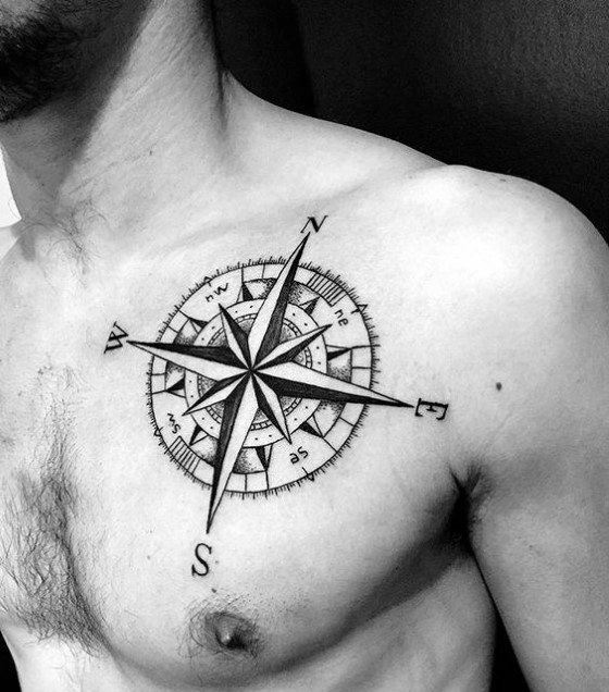 Detailed compass tattoo on chest with bold directional points, fine line shading, and numeric degree markers for a classic look.