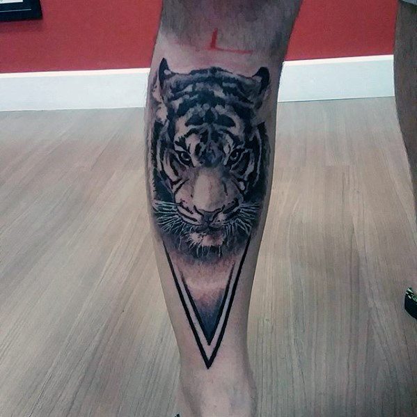 Realistic black and grey tiger tattoo on the calf, framed by a bold inverted triangle for a powerful and focused design.