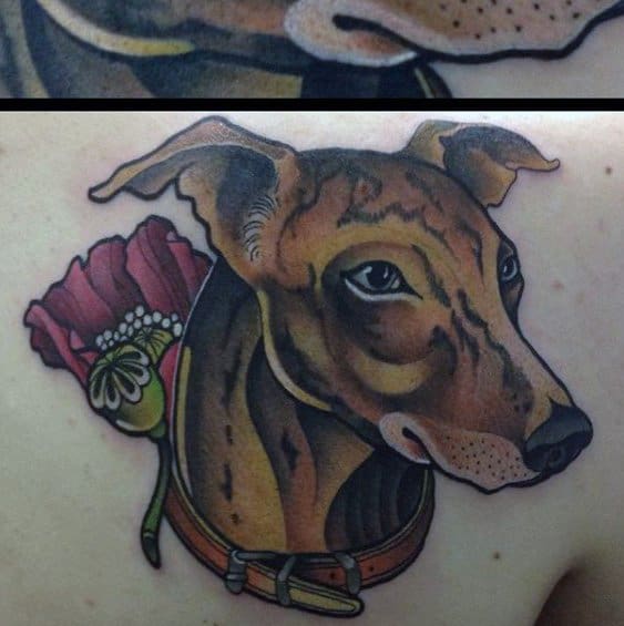 A colorful tattoo of a greyhound’s head, adorned with a vibrant red poppy flower and a collar, highlighting its gentle expression and sleek features.