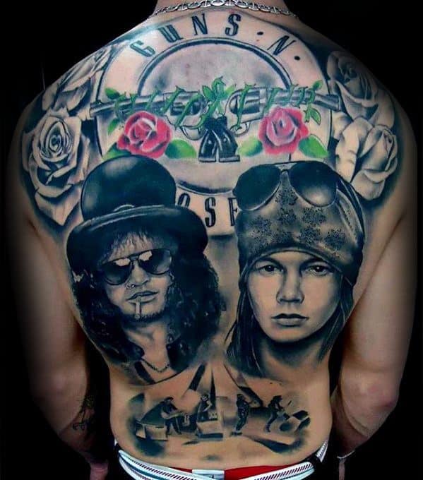 Full back tattoo featuring Guns N' Roses logo, red roses, barbed wire, portraits of Slash and Axl Rose, and a band performance scene.