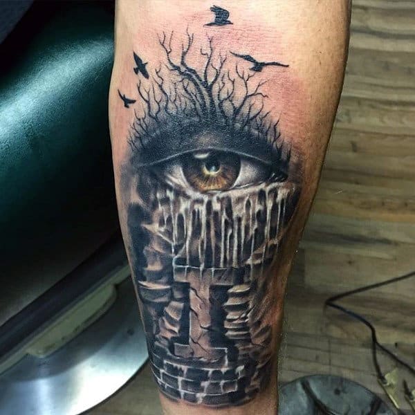 Guy With Haunted Brick Building And Eye Tattoo On Forearm