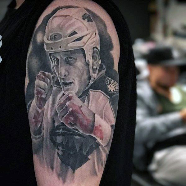 Realistic tattoo of a hockey player in mid-fight pose wearing helmet and gloves, with intense expression and detailed shading.