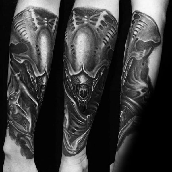 Forearm tattoo in HR Giger style showing a xenomorph-like alien with biomechanical textures and dripping mouth detail.