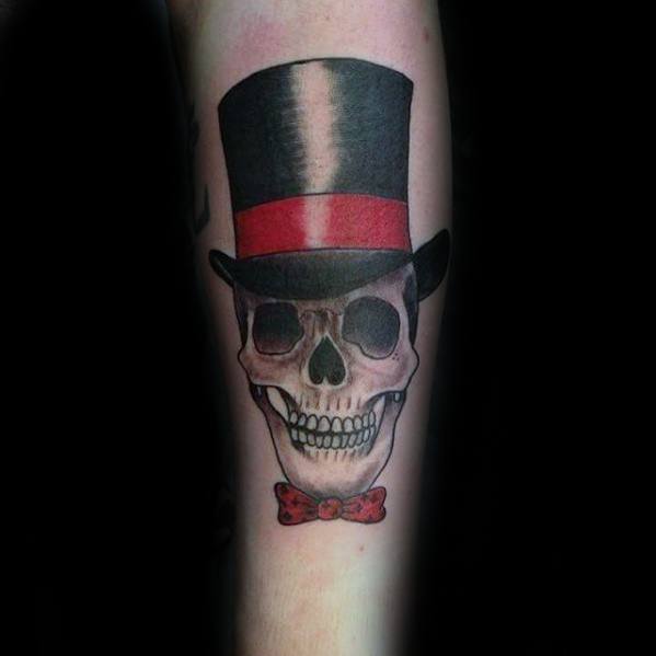 Tattoo of a skull wearing a black top hat with a red band and a red bow tie