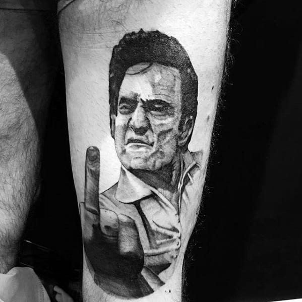 Bold black and grey tattoo of Johnny Cash, capturing his iconic rebellious pose with a defiant expression and middle finger raised, symbolizing his unapologetic attitude