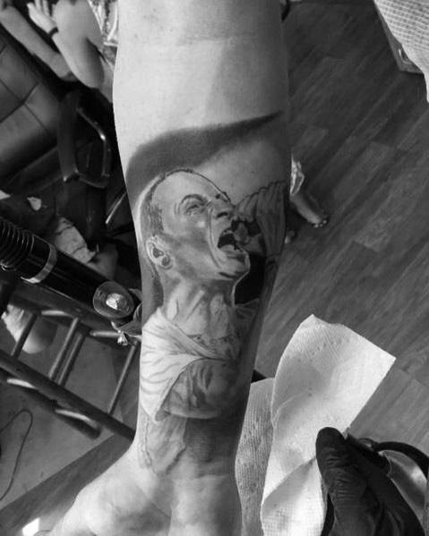 Realistic black and gray tattoo of Chester Bennington passionately singing, capturing his intensity and emotion on the forearm.