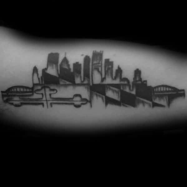 Black and grey tattoo of the Baltimore skyline with the Maryland flag pattern integrated below, creating a bold and artistic tribute to the state.