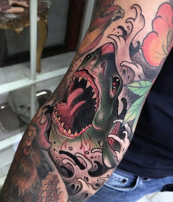 Neo-traditional shark tattoo with a wide open jaw, surrounded by bold black waves, floral elements, and dynamic shading.