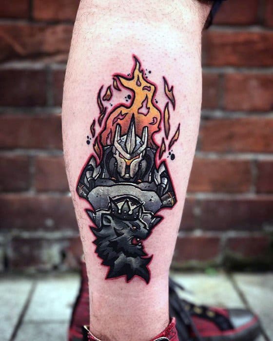 Colorful tattoo of Overwatch’s Blackhardt skin for Reinhardt, featuring fiery effects and a wolf emblem on the back of a man's leg.