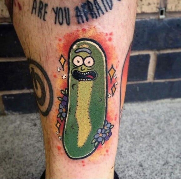 Pickle Rick tattoo with a playful design, featuring bright colors, sparkles, and flowers, placed on the lower leg with a bold outline.