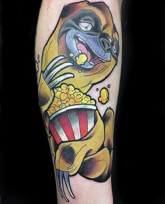 Colorful tattoo of a happy sloth munching popcorn from a red-striped bucket, with a playful expression and bold cartoon style.