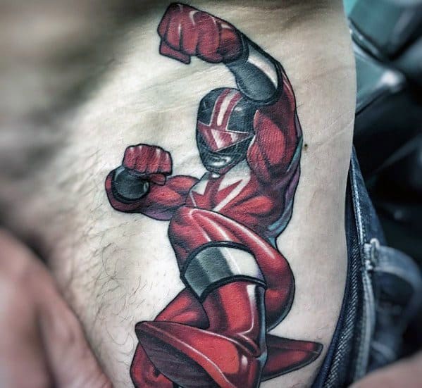 Dynamic tattoo of the Red Ranger mid-action pose, with bold outlines, muscle shading, and vibrant red tones on the side torso.