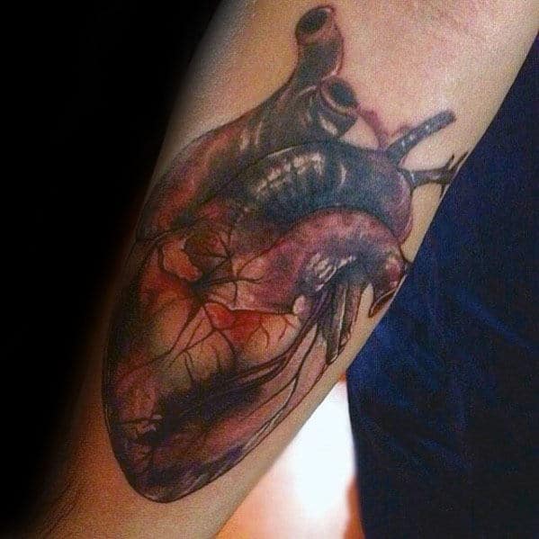 Guy With Realistic Heart Tattoo Design On Inner Forearm