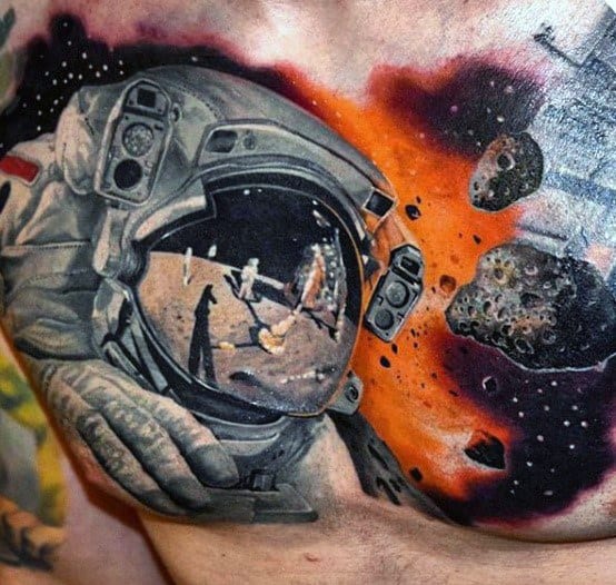 Tattoo of an astronaut's helmet reflecting a moon landing scene, surrounded by asteroids and cosmic elements in a vivid space-themed design.
