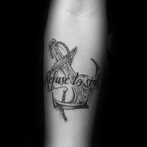 Black and gray tattoo of an anchor with a chain and the phrase "Refuse to Sink" in elegant script