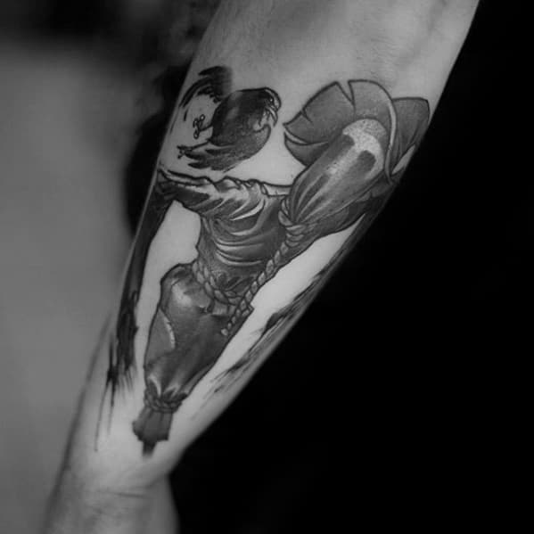 Black and grey scarecrow tattoo featuring a stitched figure with a sunflower head and a flying crow on the forearm.