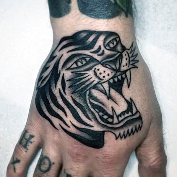 Guy With Shaded Black And Grey Traditional Roaring Tiger Hand Tattoo