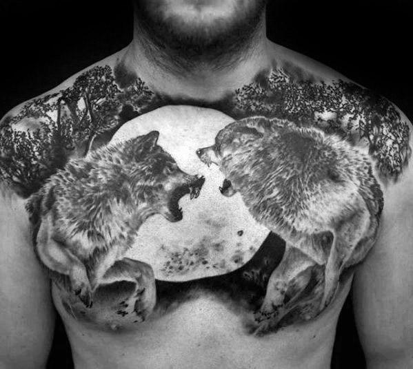 Chest tattoo of a wolf pair howling at the moon, surrounded by trees, in black and white