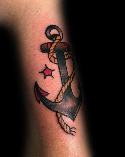 Classic anchor tattoo with a rope wrapped around it, bold black shading, red accents, and a nautical theme symbolizing strength and stability.